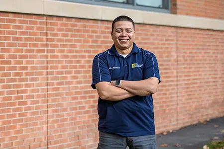 Maintenance Staff Worker standing with arms crossed and smiling.