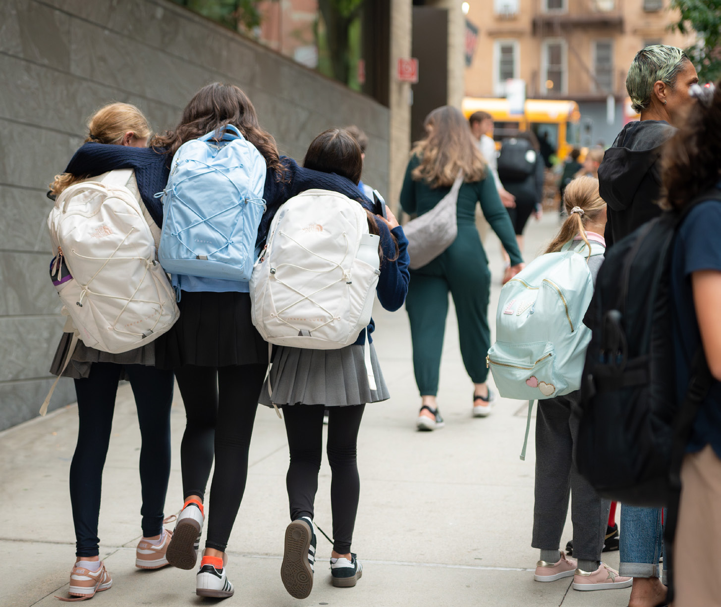 Kids walking to the bus with backpacks on
