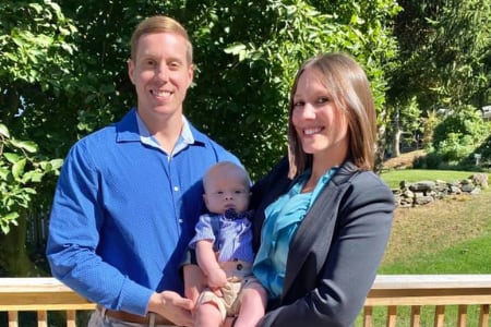 Julie and her husband holding their baby.