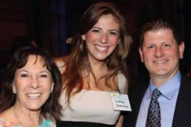three people smiling in formal attire