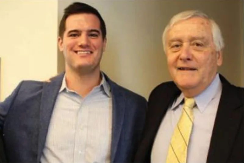 two men in suits smiling