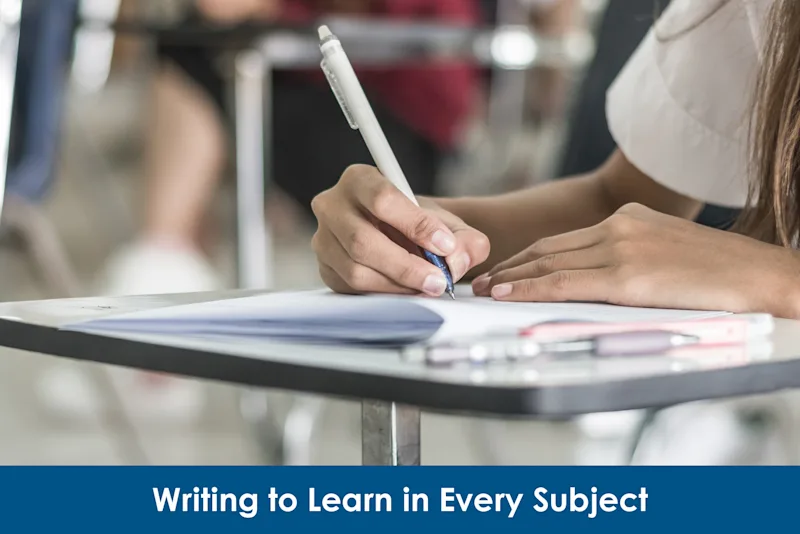 Student writing in a notebook at her desk
