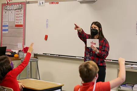 teacher wearing flannel pointing
