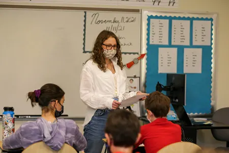 women teacher standing in front of classroom