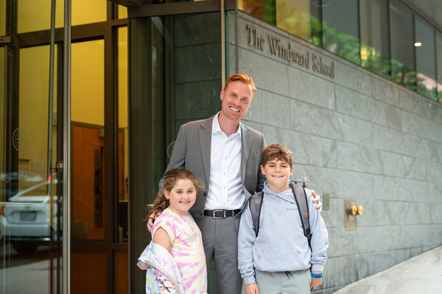 a man and two kids smiling in front of The Windward School